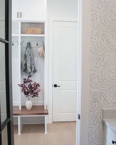 an entryway with white walls and wooden flooring