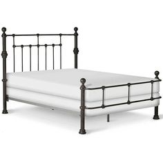 a metal bed frame with white sheets and black iron headboard, viewed from the side