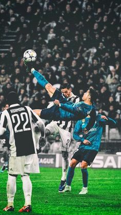 two men are playing soccer in front of an audience at a sporting event, one is jumping up to kick the ball