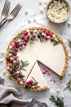 a pie with white chocolate and cranberry toppings is shown on a table