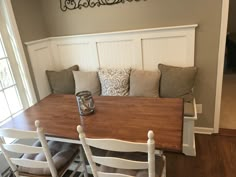 a dining room table with chairs and bench in front of the door to the kitchen