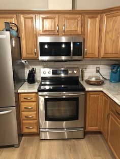 a kitchen with stainless steel appliances and wooden cabinets