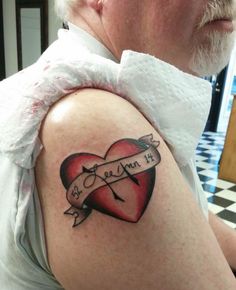 a man with a heart tattoo on his arm