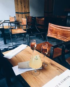 two glasses of wine sitting on top of a wooden table