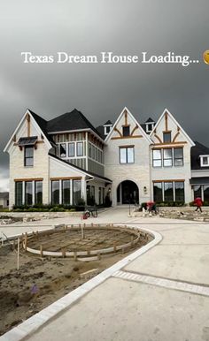 a large white house sitting on top of a dirt field