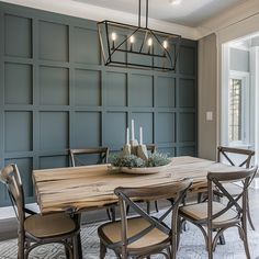 a dining room table with chairs and a chandelier hanging from it's ceiling