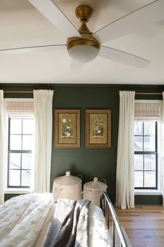 a bedroom with green walls and white curtains