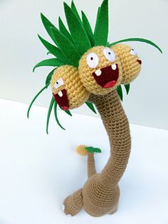 a crocheted palm tree with two faces on it's head and arms