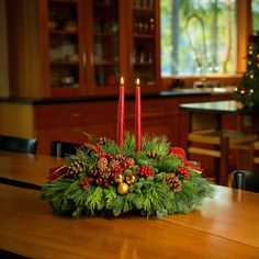 a christmas centerpiece on a table with candles