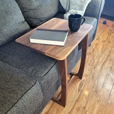 a coffee table with a book on it in front of a couch and a laptop