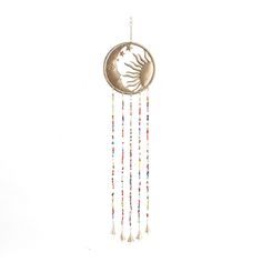 a metal wind chime with beads hanging from it's sides and a sun on the side