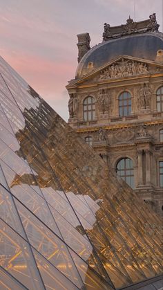 the building has many glass windows on it's sides and is next to a large pyramid