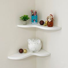 two white shelves with piggy bank, pencils and other office supplies on them