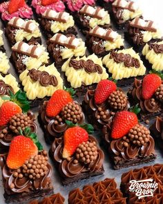 there are many different desserts on the tray with strawberries and other treats around them