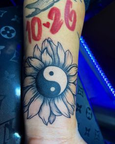 a tattoo with a sunflower and a yin - o - sign on the wrist