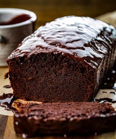 a loaf of chocolate cake sitting on top of a wooden cutting board