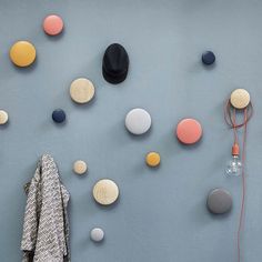 the wall is decorated with different colored balls and hats hanging on it's sides