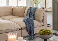 a living room with a couch, coffee table and candles on the tables in front of it