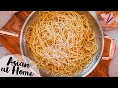 a pan filled with pasta on top of a wooden cutting board