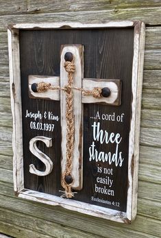 a wooden cross with rope hanging from it's sides and two words on the front