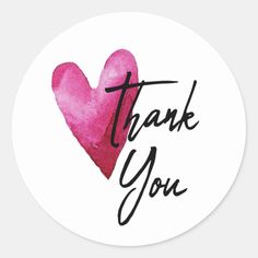 a pink heart with the words thank you in black ink on a white round sticker