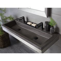 a bathroom sink sitting under a mirror next to a plant