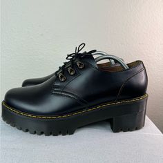 Elevate Your Shoe Game With These Black Leather Platform Boots By Dr. Martens. The Round Toe And Lace-Up Closure Provide A Classic Look, While The Mid-Block Heel And 1.1/8-Inch Platform Add A Touch Of Height And Comfort. Perfect For Travel, Parties, Casual Outings, Or Business Meetings, These Boots Come In A Solid Black Color With A Sleek Design And A Variety Of Accents, Including Lace And Logo Details. Made Of High-Quality Leather And Featuring A Rubber Outsole, These Boots Are Durable And Idea Black Platform Lace-up Oxfords, Black Leather Platform Lace-up Shoes, Black Platform Lace-up Shoes With Almond Toe, Black Lace-up Platform Shoes With Round Toe, Black Lace-up Shoes With Platform And Pointed Toe, Black High Heel Platform Lace-up Shoes, Black Chunky Platform Oxfords With Round Toe, Black Oxfords With Chunky Platform And Round Toe, Black Platform Oxfords With Closed Toe