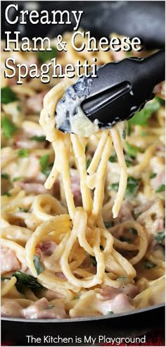 creamy ham and cheese spaghetti being lifted from a skillet with a black spatula