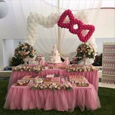 a table topped with lots of desserts and balloons in the shape of heart shapes