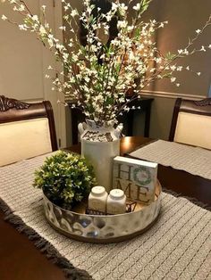 there is a vase with flowers and candles on the table