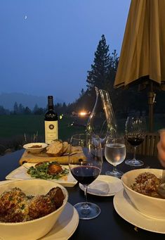 a table topped with plates of food and glasses of wine