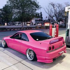 a pink car parked at a gas station