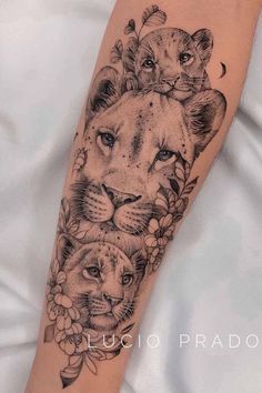 a woman's arm with two lions on it and flowers in the middle of her arm