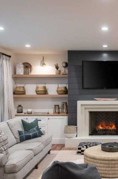 a living room filled with furniture and a flat screen tv mounted on the wall above a fire place