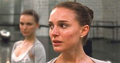 two women are standing in front of a mirror and one is looking at her reflection