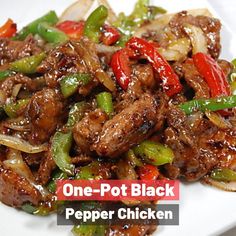 one pot black pepper chicken on a white plate with red and green peppers in the background