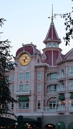 a large pink building with a clock on it's face