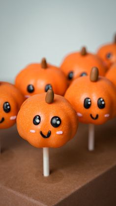 there are many orange pumpkins on sticks with faces painted on them and eyes drawn on them