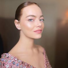 a woman with blue eyes wearing a pink dress