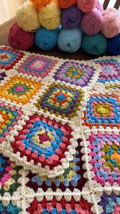 multicolored crocheted granny afghan sitting on top of a bed