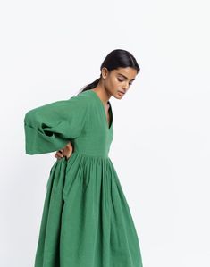 Oversized midi dress in basil green color, handwoven from cotton fabric by women artisans of India's western region. Versatile design for year-round wear. Subtle gathers at the waist for added contour to the boxy fit. Ideal for transition weather and semi-formal occasions. Billowy Green Dress, Green Billowy Maxi Dress, Green Knee-length Midi Dress With Gathered Sleeves, Midi Dress With Gathered Neckline For Gatherings, Green Cotton Dress With Gathered Sleeves, Green Spring Dress With Gathered Skirt, Spring Green Dress With Gathered Skirt, Green Oversized Cotton Maxi Dress, Oversized Green Cotton Maxi Dress