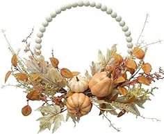 a white beaded wreath with pumpkins, leaves and acorns on it