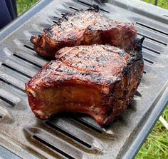 two steaks are being grilled on a grill