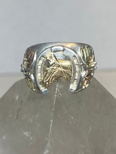 "Horse ring Black Hills Gold horseshoe leaves cowboy cowgirl sterling silver men women Size 8 Between a size 8 and a size 8.25 Weight 9.1g Length 5/8\" Width. 1/2\" Thinnest part 3/16\" Free Shipping & Free Postal Insurance Delivered in a Gift Box If you do not want the ring polished and want to leave the natural patina please let me know at the time of purchase as I do polish rings before I ship rings out. Thanks Free First Class shipping and postal insurance is included. If you want to upgrade Western Style Silver Horseshoe Jewelry, Silver Adjustable Horseshoe Rings, Western Engraved Jewelry For Rodeo, Western Style Engraved Jewelry For Rodeo, Western Style Sterling Silver Rings, Western Style Sterling Silver Rings In Silver, Western Style Silver Jewelry, Western Style Stamped 925 Rings As Gift, Western Style 925 Silver Rings As Gifts