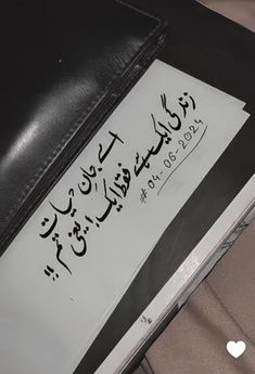 a piece of paper that has been placed on top of a laptop computer with arabic writing