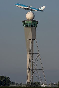 an airplane is flying over the control tower