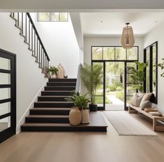 there is a staircase in the house with plants and potted plants next to it