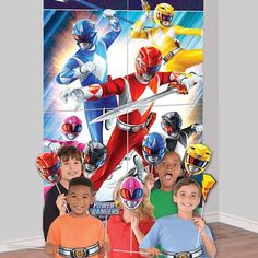 a group of children standing in front of a wall mural with power rangers on it