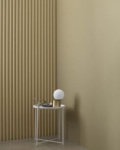 a small table with a white ball on it in front of a vertical striped wall