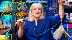 an older woman holding up a toothbrush in front of a store display with beads and bead